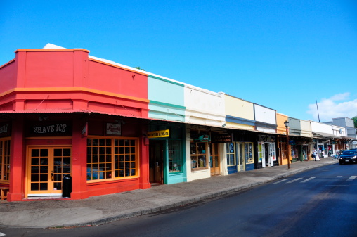 Lahaina, HI, United States - July 14, 2012: Facades of colourful tourist stores in the heart of Lahaina's tourist district. The red store in the foreground is a shaved ice store. 