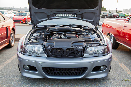 Dartmouth, Nova Scotia, Canada - August 22, 2013: At a public car gathering, a BMW M3 E46 with hood up parked in a parking lot.  In background, some other cars are visible.  The E46 M3 was first introduced in 2000 and features 333 HP from a 3.2 litre engine.  The BMW M3 is considered one of the best sports cars of all time and is a benchmark in sports performance.
