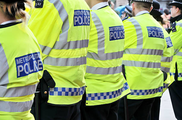 Metropolitan Police Officers, London, UK "London, United Kingdom - 12th May 2012. Metropolitan Police Officers wearing Hi-Viz jackets ensuring public safety during a protest march held by ""Occupy""." metropolitan police stock pictures, royalty-free photos & images