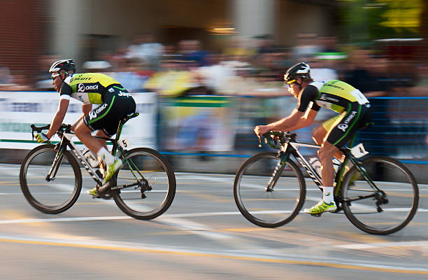 dwóch motocyklistów zawodowych i blur z widzów, - track cycling zdjęcia i obrazy z banku zdjęć