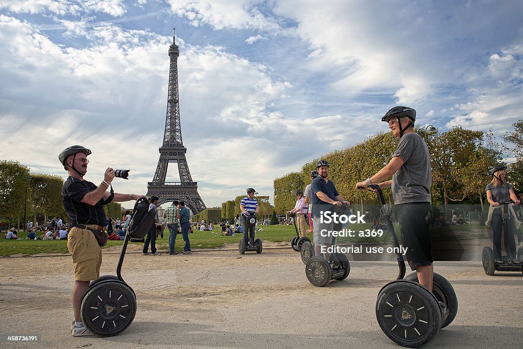 Guided Segway Tour of Paris "Paris, France - September 10, 2011: A group of tourists take snapshots in the park near the Eiffel tower during  their guided Segway tour in Paris." Segway Stock Photo