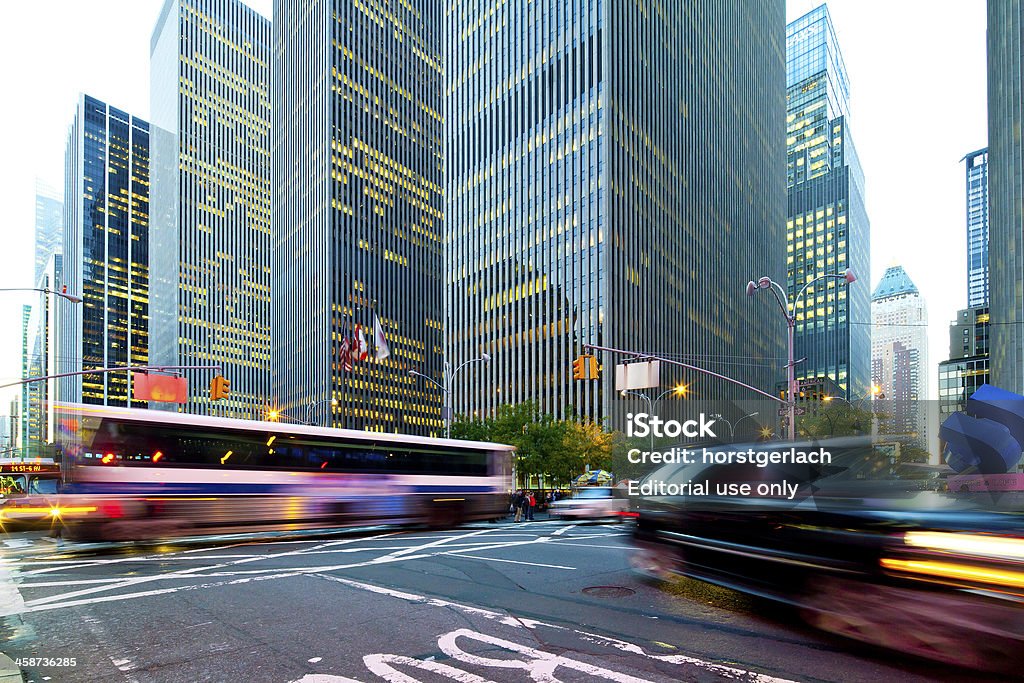 New York City, Rockefeller Center at night "New York City, USA - November 02, 2011: View down the illuminated 6th Avenue at night. The huge buildings of the Rockefeller Center on the right. Town cars and buses passing by. Photo taken with 17mm wide angle tilt and shift lenses." Architecture Stock Photo