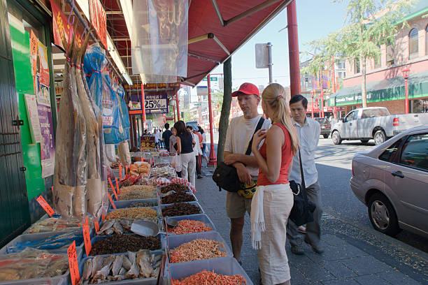les gens biens dans le quartier chinois de vancouver - store market china city street photos et images de collection