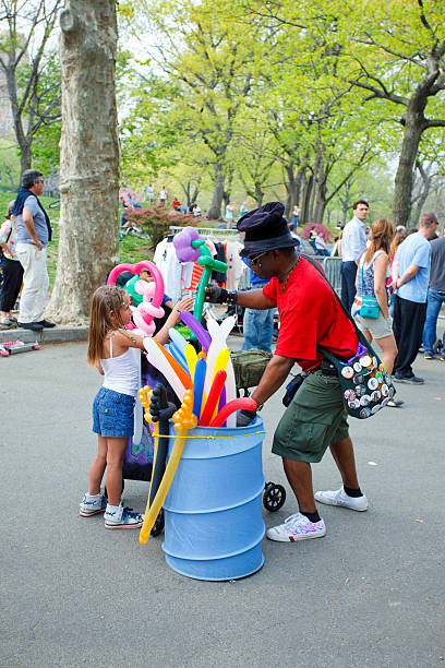 Two women make the finishing touches on burying a small boy partially in sand, turning him into a mer-man.