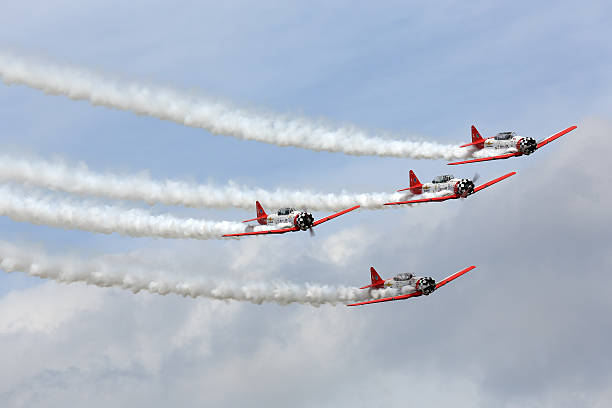 Aerobatic team performing during Oshkosh AirVenture 2013 "Oshkosh, WI, USA - August 2, 2013: The AeroShell Aerobatic Team performing during the EAA AirVenture fly-in at Oshkosh Wisconsin." airshow stock pictures, royalty-free photos & images