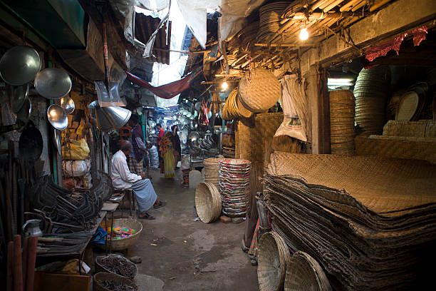 Alley with small retail shops selling handmade goods. "Sylhet, Bangladesh - February 06, 2012: An alley with small retail shops selling handmade goods like baskets and kitchen utensils." sylhet stock pictures, royalty-free photos & images