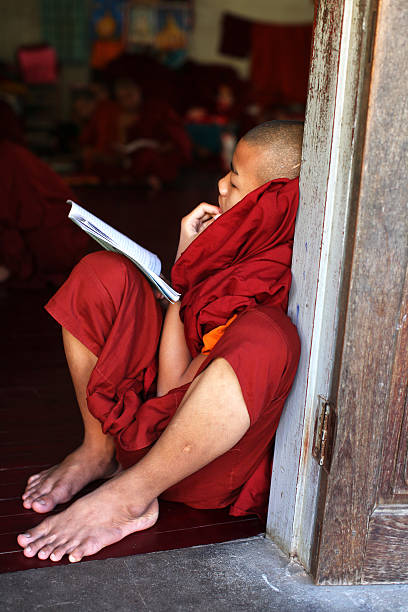 подростковая монах-послушник учиться на монастырь в янгоне, бирма - buddhism monk book zen like стоковые фото и изображения