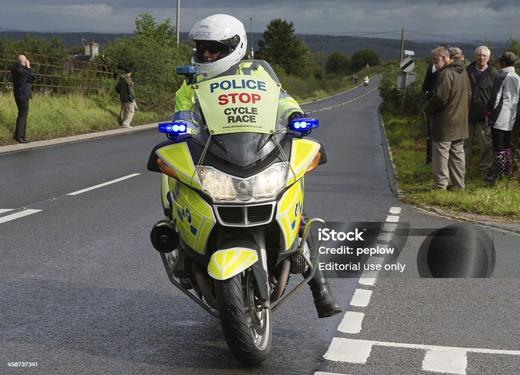 Waiting "North Staffordshire, UK -September 18th 2013: Police Motorcyclist enforces a rolling road block as spectators gather to watch the Tour of Britain Cycle Race pass over the border into Shropshire." Police Force Stock Photo