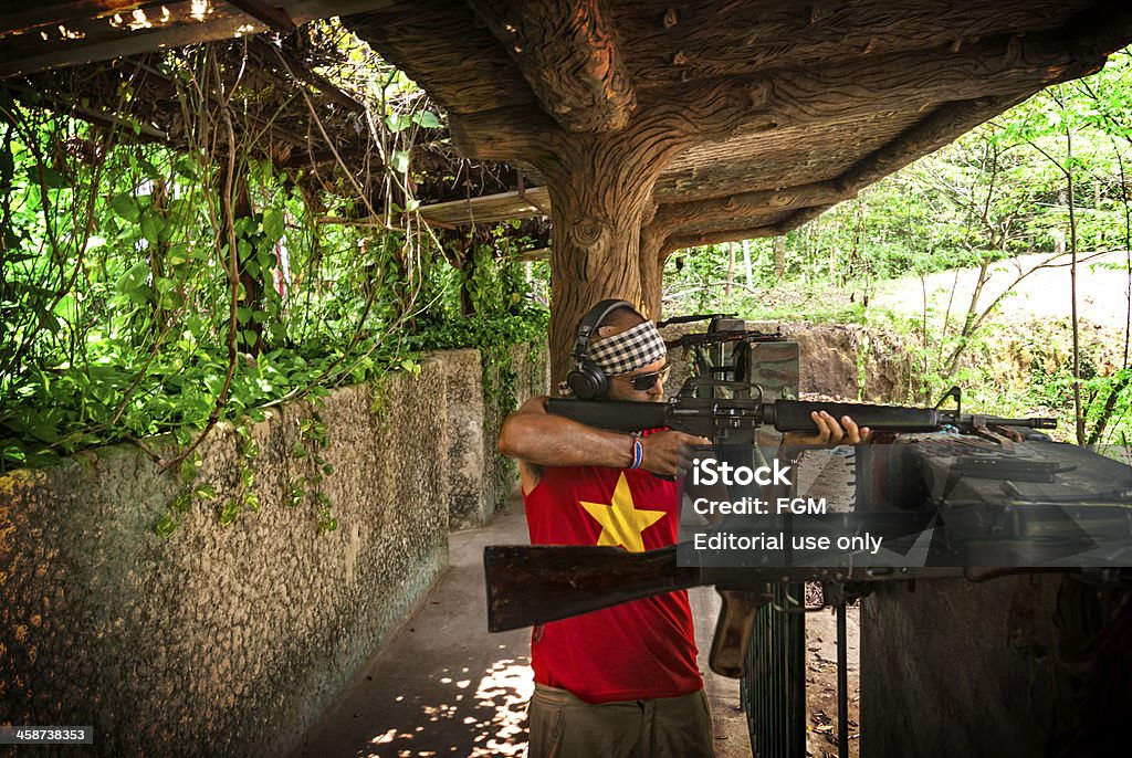 Target Practice Chu Chi Tunnels, Ho Chi Minh City, Vietnam - 27th June 2010:  A tourist visiting the Chu Chi Tunnels in Vietnam pays to fire live rounds from an M16 assault rifle down a shooting range.  This is very popular with tourists visiting this tourist attraction and thousands of people each year attend.  It is supervised event that tourists have to pay extra for. AK-47 Stock Photo