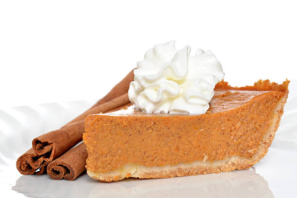 A slice of pie with three decorative cinnamon sticks