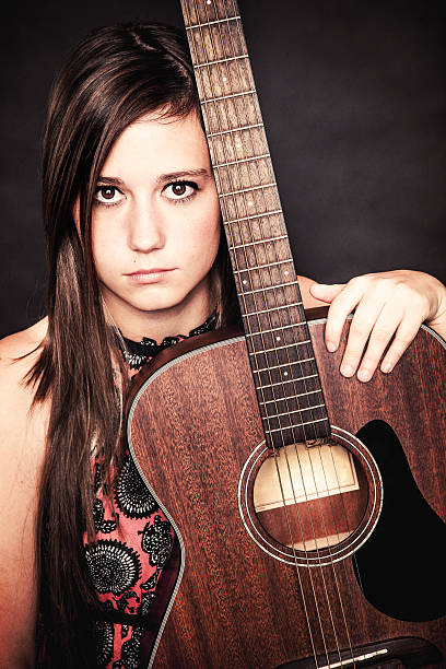 istock Beautiful Young Woman Holding a Guitar 458804135