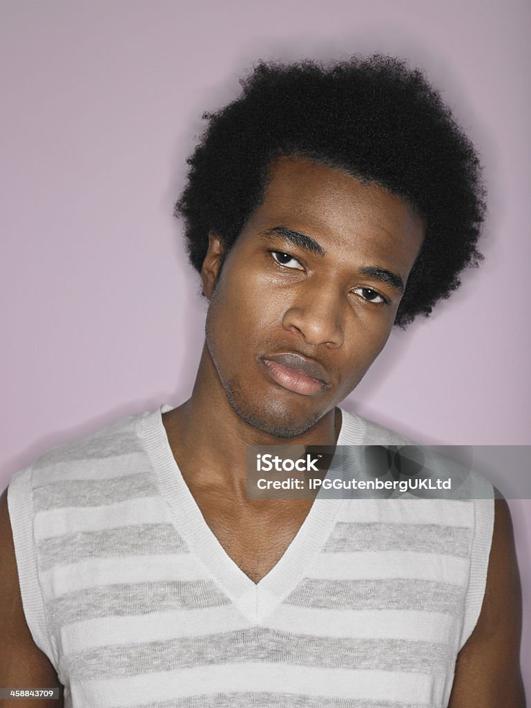 Portrait de jeune homme contrarié Coiffure Afro - Photo de Fond rose libre de droits