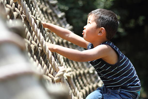 Japanese boy climbing the rope ladder (3 y/o)