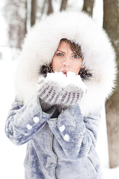 istock Winter woman Blowing Snow 458844361