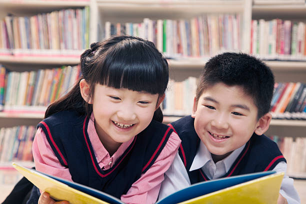 istock School children reading book a in the library 458848305