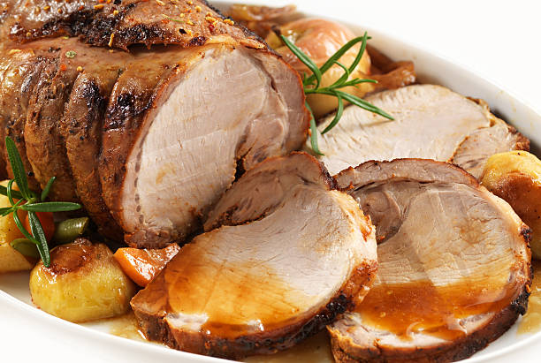 Sliced roasted pork with garnish on an oval plate roasted pork on white plate pork stock pictures, royalty-free photos & images