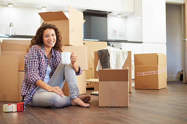 istock Woman with coffee cup surrounded by moving boxes 458859763