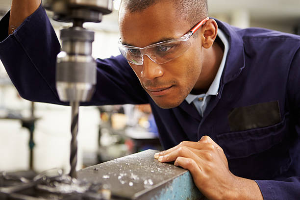 Apprentice Engineer Using Milling Machine Close Up Of Apprentice Engineer Using Milling Machine safety glasses stock pictures, royalty-free photos & images