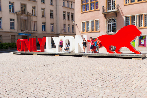 Lyon, France - July 27, 2013: Tourists standing in front or in the big letters of the tourism slogan \