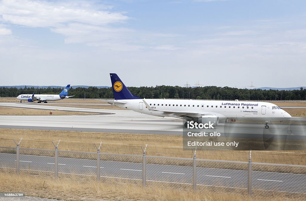 Lufthansa Embraer ERJ-190-100LR Frankfurt, Germany - July 23, 2013: A Lufthansa aircraft taxiing on runway Northwest at Frankfurt Airport. German airline Lufthansa is the largest airline in Europe and the world's fifth-largest airline and part of the intercontinental airline network Star Alliance. Some minor motion blur. In the background a Boeing 767 of Airline Condor Airplane Stock Photo