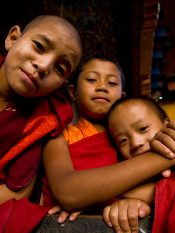 Lobesa, Bhutan - October 26th, 2010: Young monks in front of the Divine Madman's fertility temple the Chimi Lhakhang where women go to get pregnancy blessings. At this monastery, the tradition is to strike pilgrims on the head with a 10 inch (25 cm) wooden phallus