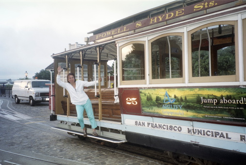 San Francisco, USA-September 15, 2003:  A tourist waves from the Powell & Hyde Sts. cable car in San Francisco California.  San Francisco is the only city in the USA with this unique transportation system.