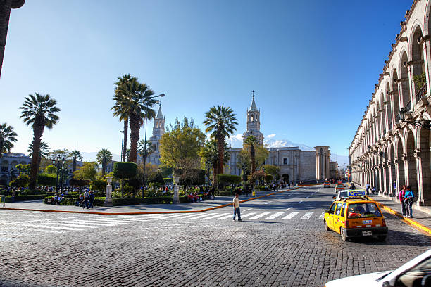 Arequipa Cathedral in the town square Plaza De Armas Arequipa, Peru - May 25, 2013: Arequipa Cathedral in the town square Plaza De Armas. Traffic and pedestrians are also pictured in the scene arequipa province stock pictures, royalty-free photos & images