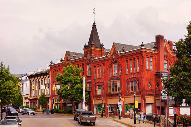 Bellefonte, USA - July 20, 2013: Pedestrians crossing bridge with the ornate buildings of High street in the background, in the Victorian area of Downtown Bellefonte, Pennsylvania.