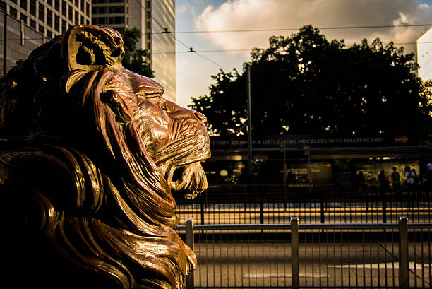 Central, Hong Kong - July 5, 2013: Symbol of HSBC, the lion sculpture, looking over the other parts of Central in Hong Kong, through good times and bad times.