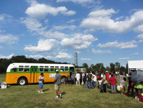 Washington DC, USA-August 24, 2013:  People line up to board the Rosa Parks bus and hear a lecture for the 50th anniversary of the civll rights march on Washington DC. On 12/1/1955 Rosa Parks along with other black passengers were ordered out of their seats by the driver as they sat in the colored section of the bus.  The bus was crowded and white passengers needed a seat.  All of the colored or black people obeyed except Rosa Parks who was arrested for civil disobedience.  Dr. Martin Luther King Jr. organized a successful boycott against the Montgomery Atlanta bus company and the rest is history.  This was a turning point in the fight for civil rights for black people.