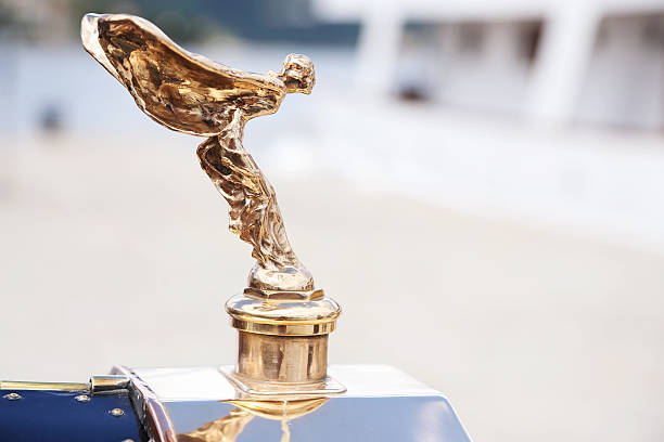 Spirit of Ecstasy Opatija, Сroatia - June 25, 2013: The front end of the beautiful old Rolls Royce with the hood ornament, Spirit of Ecstasy, parked on waterfront of Opatija. The ornament is in the form of a woman leaning forwards with her arms outstretched behind and above her. Billowing cloth runs from her arms to her back, resembling wings. rolls royce stock pictures, royalty-free photos & images