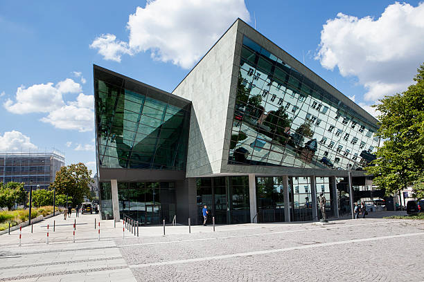 Darmstadt, Germany - August 14, 2013: The back side of darmstadtium, Darmstadt. darmstadtium is a large conference and convention center in Darmstadt. Darmstadt is a city in Hesse and located in the South of the Rhine-Main-Area, it has a population of app. 150,000. Some passersby in the foreground