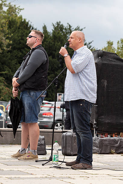 NPD Election campaign, Wiesbaden Wiesbaden, Germany - August 26, 2013: Member of the NPD Matthias Faust gives a xenophobic speech during an election campaign in the city of Wiesbaden, surrounded by bodyguards and supporters. Founded in 1964 the NPD is a German nationalist party, its agitation is racist, antisemitic, revisionist. Because of its activities against the constitutional order the party is under observation of the Verfassungsschutz (German Federal Intelligence agency) national democratic party of germany stock pictures, royalty-free photos & images