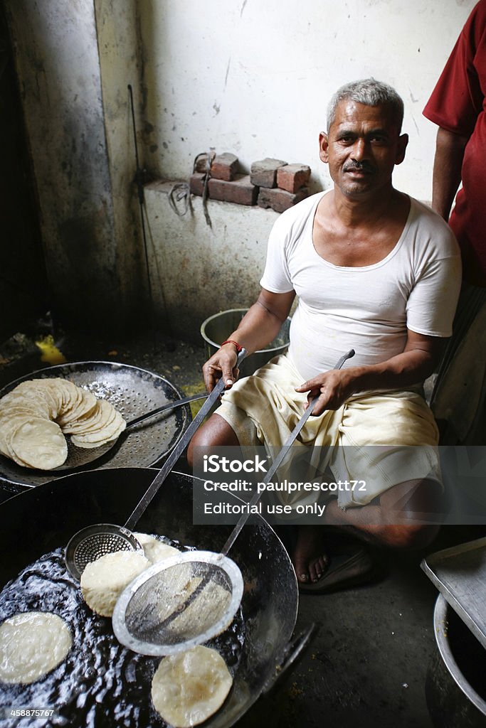 man making puri Dehli, India- February 26, 2008. Man cooking chapatis in oil to make Puri on February 26, 2008 in Dehli, India. Chapatis are the staple diet of all Indians. Active Seniors Stock Photo