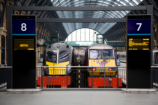 London, England - February 21, 2013: Two trains on platforms 8 and 7 King's Cross Station.  Victorian architecture with modern display boards. Stopped at the buffers.