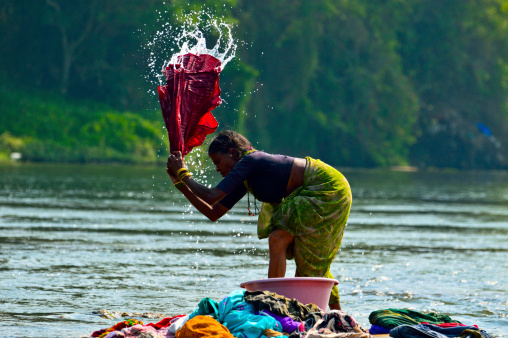 Mysore, India - March, 24, 2012: Indian washerwoman washing clothes in caveri river near Mysore