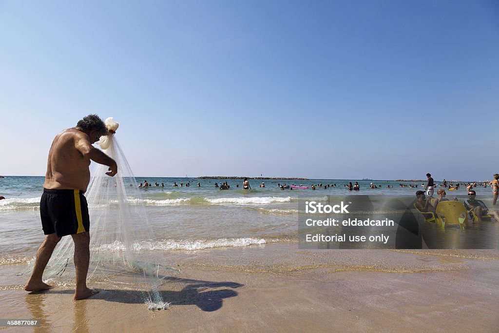 Rybak ciągnąc netto w Tel Awiwie Beach - Zbiór zdjęć royalty-free (50-54 lata)