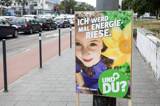 Election campaign billboard of DIE GRUENEN / Bundestagswahlkampf Darmstadt, Germany - August 13, 2013: Election campaign billboard of the German DIE GRUENEN in the city center of Darmstadt. Germany faces federal elections scheduled for September 22. Some passersby and road users in the background. german federal elections photos stock pictures, royalty-free photos & images