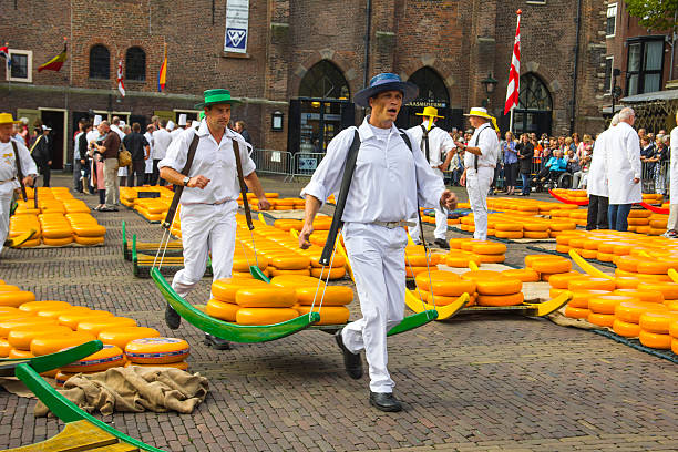 Carriers walking in the famous Dutch cheese market Alkmaar, The Netherlands - September 7 2012: Carriers walking with cheese at a famous Dutch cheese market. porter photos stock pictures, royalty-free photos & images