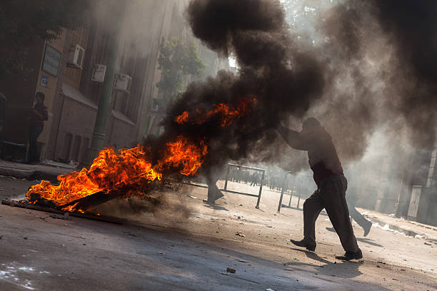 Manifestante blocco street con fuoco - foto stock