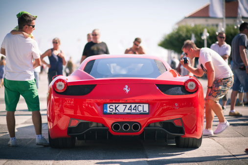 Sopot, Poland - 17 August 2013. People looking at a red Ferrari 458 Italia supercar presented by a Ferrari dealer in Sopot. Presentation was part of the Sopot Match Race 2013 sailing event.