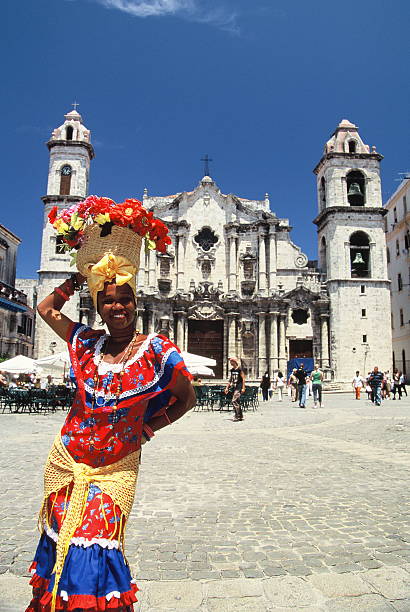 Havana, Cuba - 29 April, 2005: Cuban woman  is sitting before the Havana Cathedral with flowers on her head on a sunny day.
