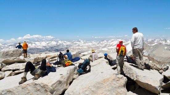 Mount Whitney, California, USA - June 30, 2010: Hikers rest after a strenuous climb on June 30, 2010, on the summit of Mount Whitney. In 2009 ca. 25,000 people summited the highest peak in the continental United States.