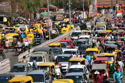 Delhi, India, - March 23, 2013: Many cars, auto rickshaws, people cause heavy traffic jam as usual on Chandni Chawk street in Old Delhi where in front of Red Fort entrance. It is daily view of the street many places in Delhi.