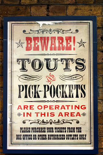 London, United Kingdom - October 23, 2009 : A vintage poster on the outside wall of the Theatre Royal, Drury Lane, warning theatre patrons to beware of ticket touts and pick-pockets operating in the area and to purchase tickets from the box office or other autorised outlets only.