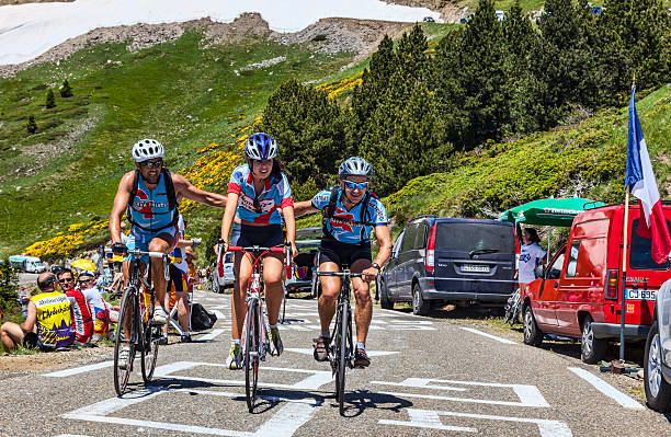 Amateur Cyclists in Pyrenees Mountains Port de Pailheres,France- July 6, 2013: Group of three amateur cyclists helping each other while climbing the difficult road to Col de Pailheres in Pyrenees Mountain before the apparition of the peloton during the stage 8 of edition 100 of Le Tour de France 2013. tour de france stock pictures, royalty-free photos & images