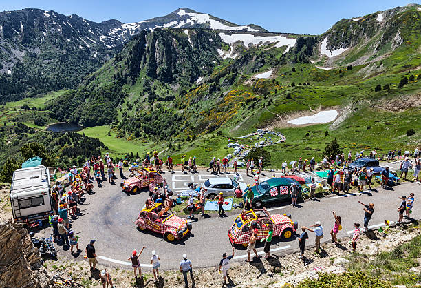 Publicity Caravan in Pyrenees Mountains Port de Pialheres, France- July 6th, 2013: Row of Cochonou vehicles driving on the road to Col de Pailheres (Pyrenees Mountains), during the passing of the publicity caravan before the apparition of the peloton during the stage 8 of the 100 edition of Le Tour de France on July 6 2013.Cochonou is an important French brand of short dry sausages, which sponsor the competition. tour de france stock pictures, royalty-free photos & images