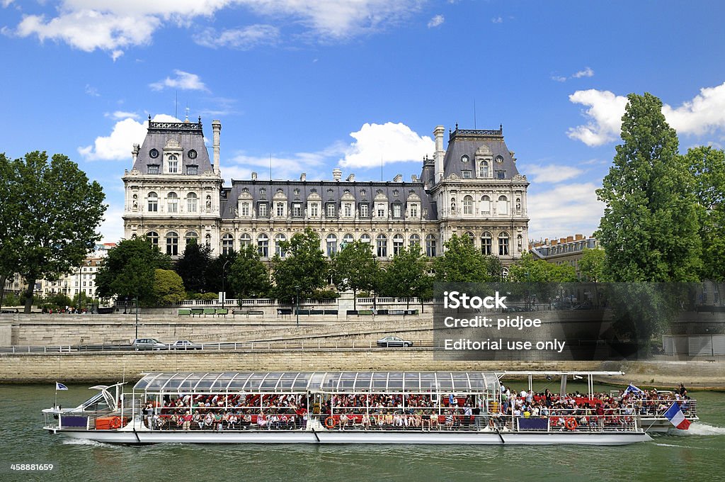tourboat crowded with tourists on Seine river, Paris France Paris, France - July 12, 2008: tourboat crowded with tourists sailing on Seine river past Hotel de Ville in Paris France. The tourboats are owned by Bateaux Parisiens and make one hour sightseeing tours on the Seine river, during which many monuments and places of importance can be seen. The tours are very populair amongst tourists visiting Paris. Hotel de Ville - Paris Stock Photo