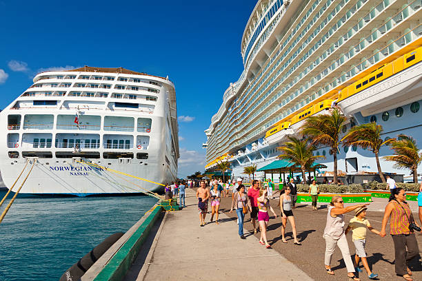 Grand Turk, Turks and Caicos Islands - April 03 2014: Carnival Liberty and Carnival Victory Cruise Ships moored side by side at the Grand Turk Cruise Terminal. Passengers make their way onto the island using the pier onto Cruise Center (SunRay) Beach.
