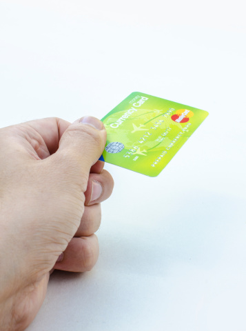 Derby, England, United Kingdom - August 18, 2013: A man's hand is holding a master card, as if he is paying with it. The photo was taken in a photo studio in front of a white background.